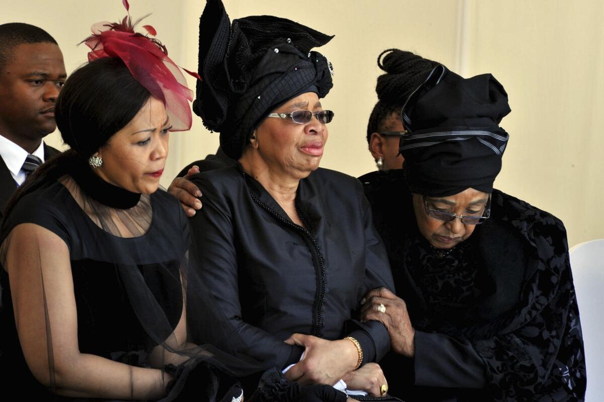 Nelson Mandela's ex-wife Winnie Madikizela-Mandela, right, comforts his widow Graca Machel, center, during the burial ceremony for the South African leader last December.