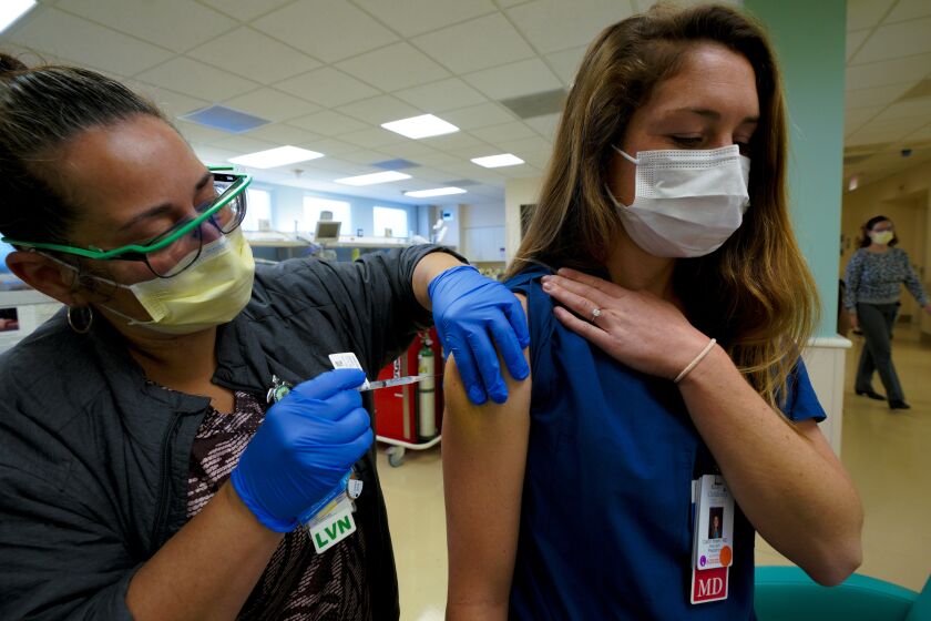 SAN DIEGO, CA - DECEMBER 22: At Rady Children’s Hospital on Tuesday, December 22, 2020, health care workers receive their first of two doses of the COVID-19 Moderna vaccine. Joey West, LVN inoculates Caitlin Breen, MD with the COVID-19 Moderna vaccine on Tuesday. (Nelvin C. Cepeda / The San Diego Union-Tribune)