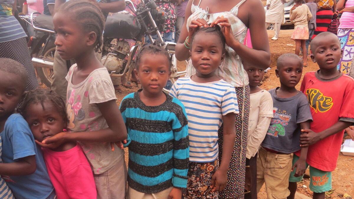 In this Aug. 19 photo, children displaced by floods and mudslides wait for food ration in Freetown, Sierra Leone.