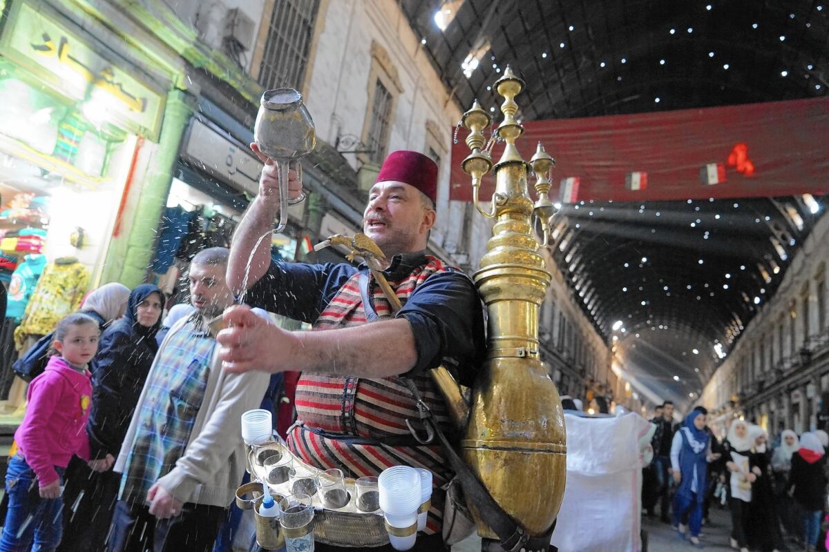 Isahak Kraymeen sells tamarind juice at the Hamidiya souk in Damascus, Syria.
