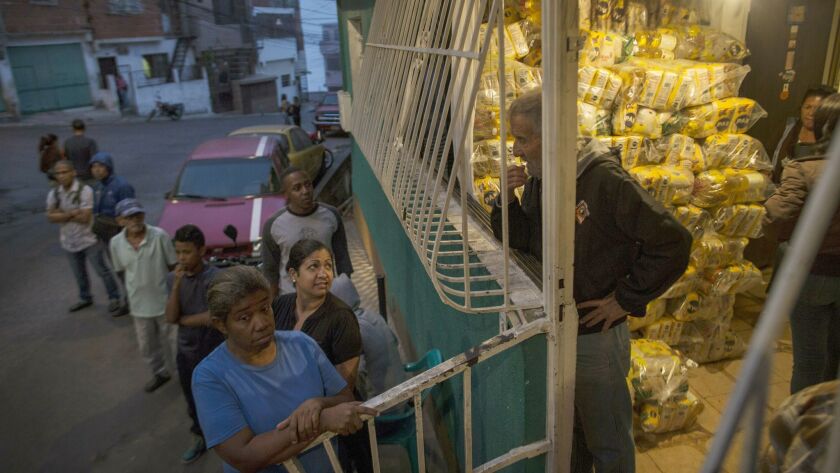 People wait in line for subsidized food distributed under a government program called CLAP in Caracas, Venezuela, on Jan. 31.