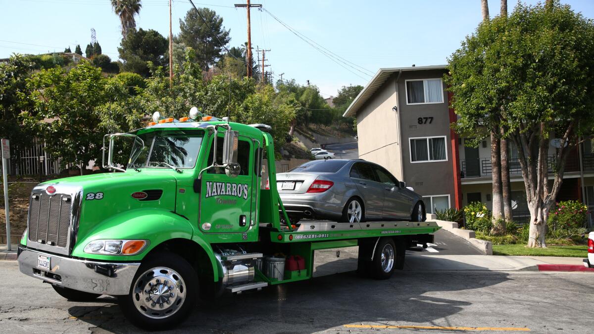 A tow truck hauls away a Mercedes-Benz in which Saieed Ivey was found shot to death.