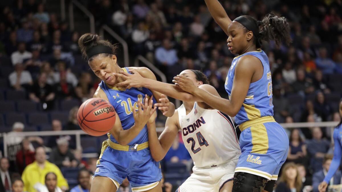 UCLA forward Lajahna Drummer, left, strips the ball from Connecticut forward Napheesa Collier, with UCLA guard Kennedy Burke defending during a regional semifinal game in the NCAA women's tournament on Friday in Albany, N.Y.