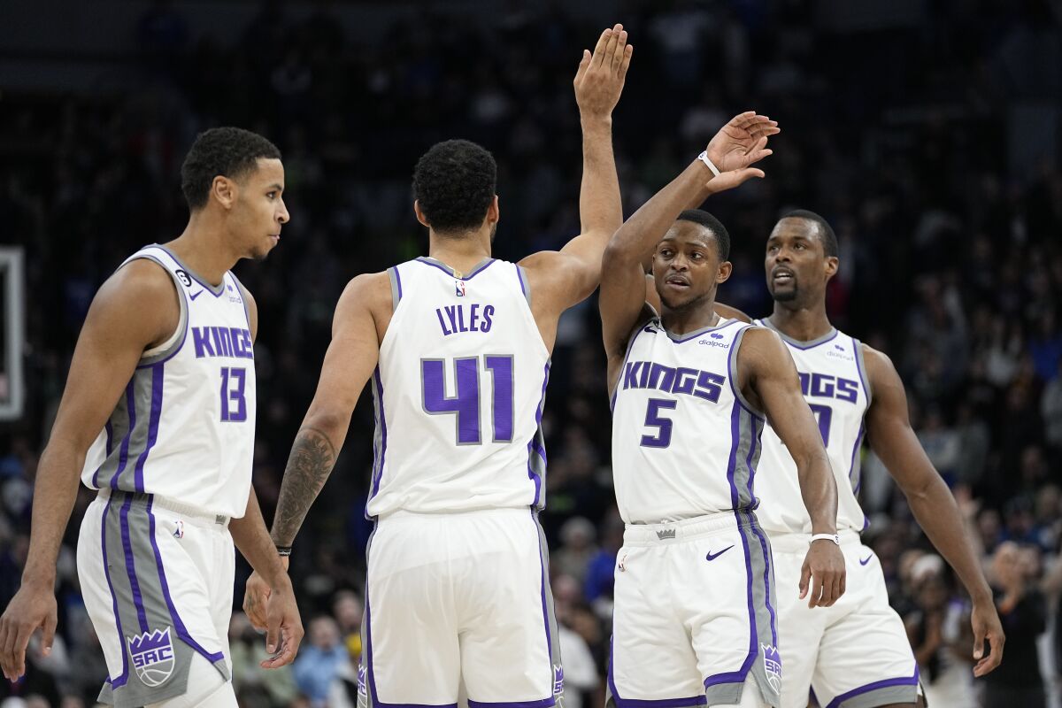 From left to right, Sacramento Kings forward Keegan Murray (13), forward Trey Lyles (41), guard De'Aaron Fox (5) and forward Harrison Barnes celebrate during overtime of an NBA basketball game against the Minnesota Timberwolves, Monday, Jan. 30, 2023, in Minneapolis. (AP Photo/Abbie Parr)