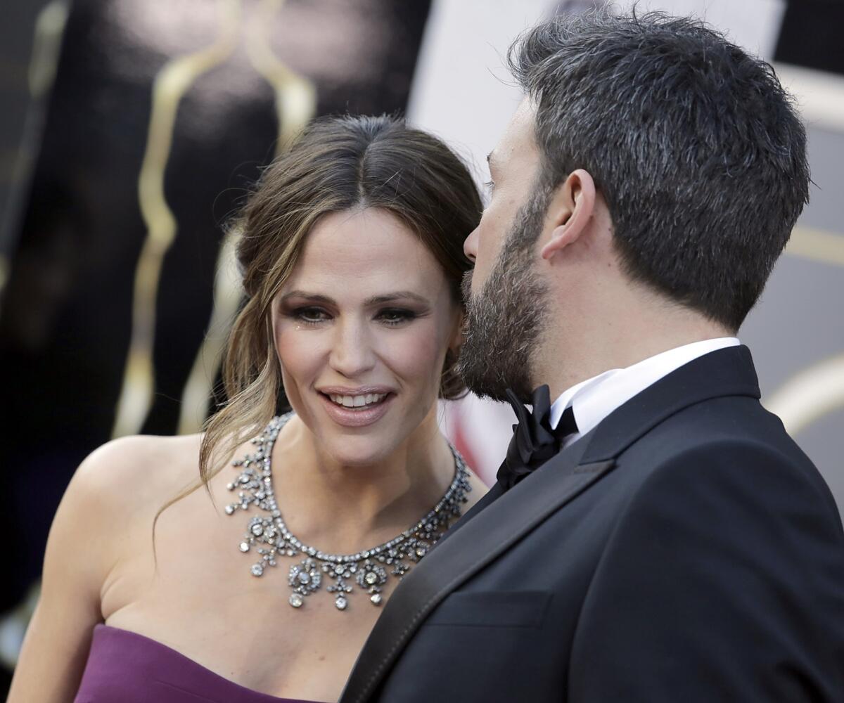 Actress Jennifer Garner reportedly snapped a photo of a paparazzo recording her and her children. She is seen here with husband Ben Affleck at the Academy Awards in February.