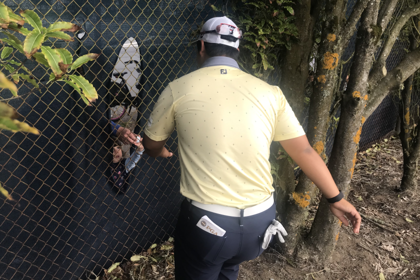 Joohyung Kim hands a signed golf ball through the fence by the No. 12 tee box to 3-year-old Quinn Gleason.