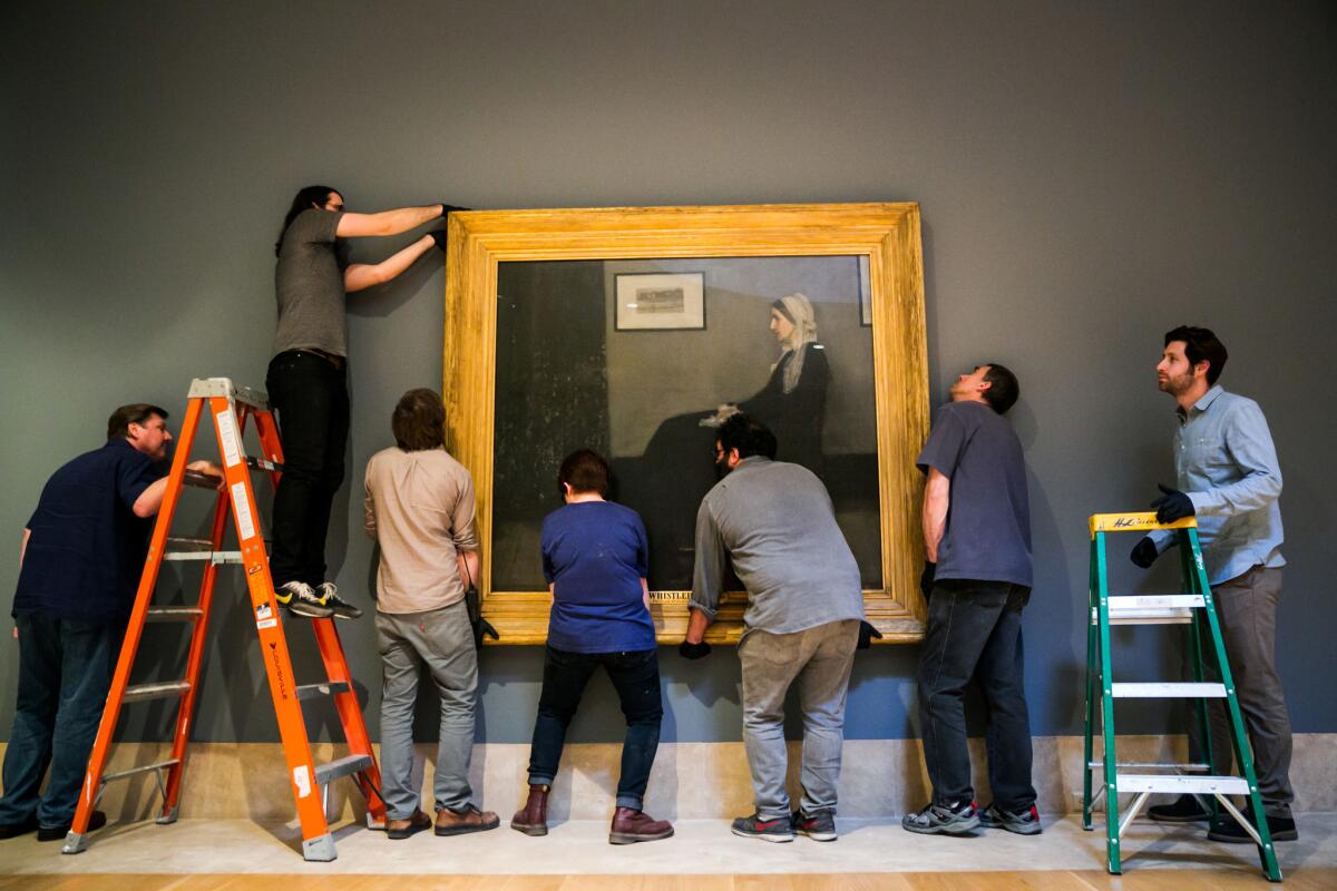 Museum workers mount and align James Abbott McNeill Whistler's "Whistler's Mother" onto the wall for display at the Norton Simon Museum.