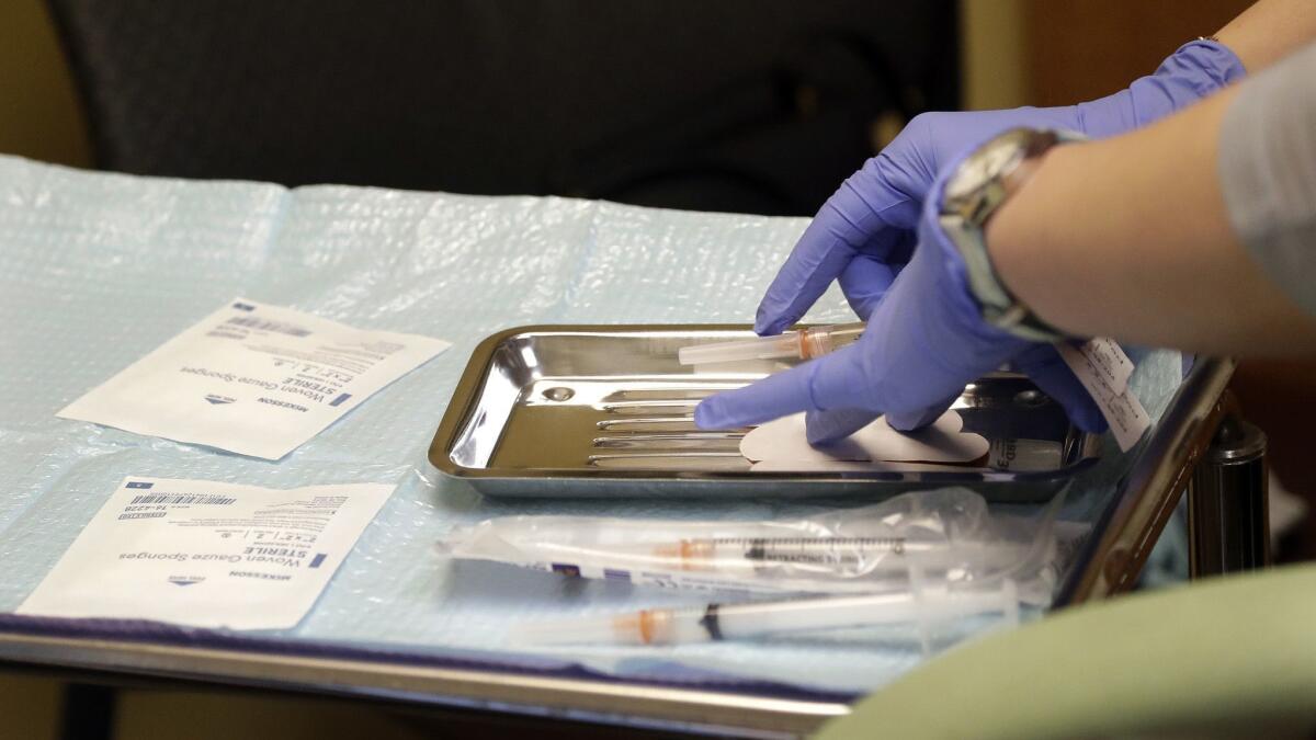 A healthcare worker prepares syringes to vaccinate children against measles, mumps and rubella at a Seattle clinic. An outbreak in Washington state has helped push the number of confirmed measles cases in the U.S. to 206 in January and February alone.