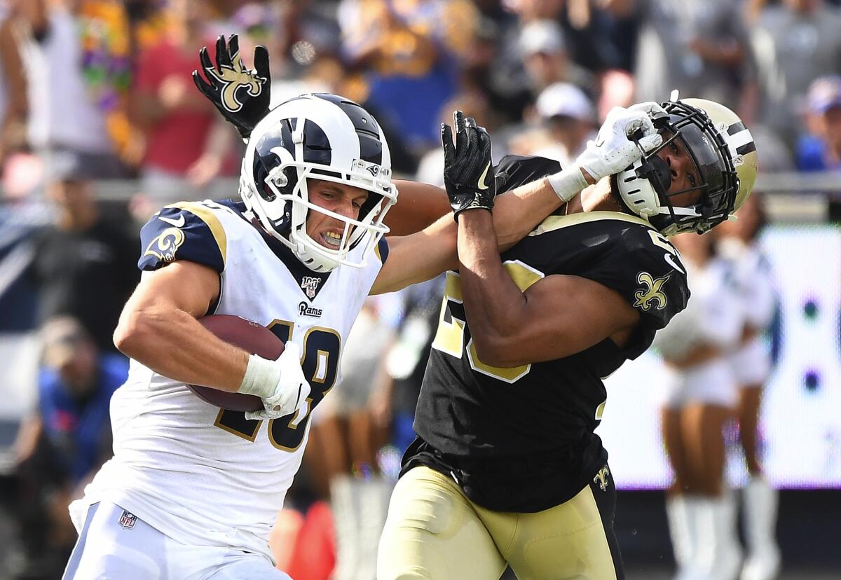 Rams receiver Cooper Kupp stiff-arms Saints cornerback Marshon Lattimore.