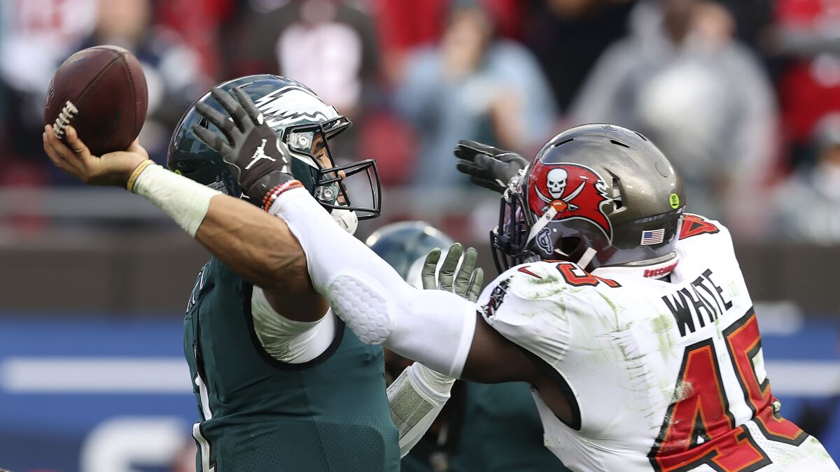 Tampa Bay Buccaneers inside linebacker Devin White (45) runs into Philadelphia Eagles quarterback Jalen Hurts (1) as he attempts a pass during the second half of an NFL wild-card football game Sunday, Jan. 16, 2022, in Tampa, Fla. (AP Photo/Mark LoMoglio)