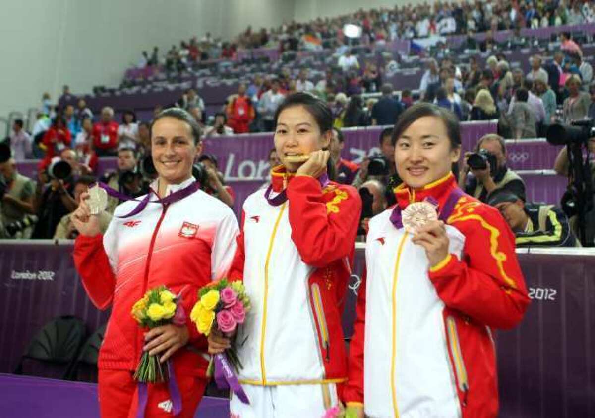Gold medalist Yu Siling, center, stands with silver medalist Sylwia Bogacka, left, and bronze medalist Yu Dan.