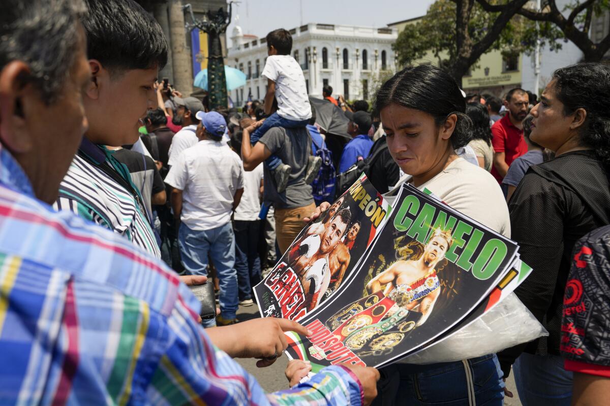 Fans buy posters of Mexican boxer Saul "Canelo" Alvarez during his weigh-in ceremony 