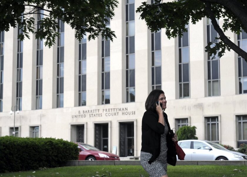 A woman talks on the phone in front of the U.S. Courthouse in Washington on Thursday where the secret Foreign Intelligence Surveillance Court resides. The court granted an order by the National Security Agency for Verizon to secretly turn over the telephone records of millions of U.S. customers.