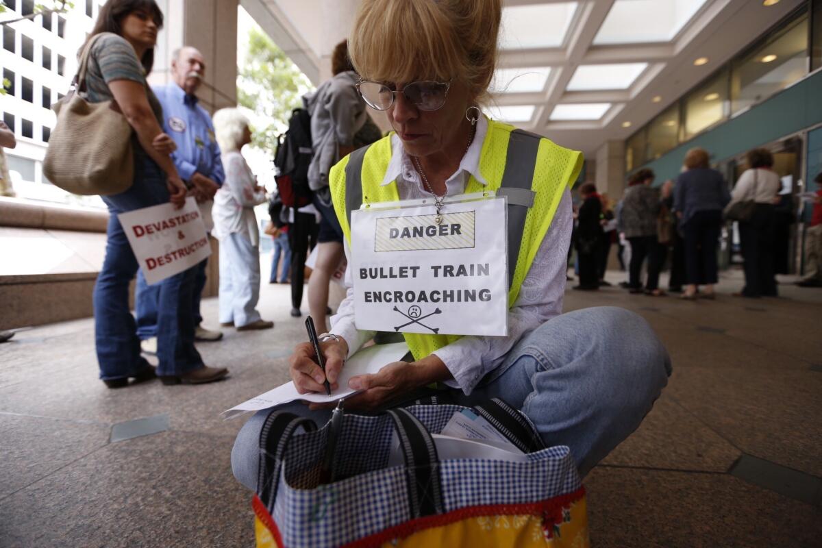 Shannon McGinnis from Kagel Canyon joins opponents of the current route for a high speed rail before they converge on a meeting of the California High-Speed Rail Authority in downtown Los Angeles.