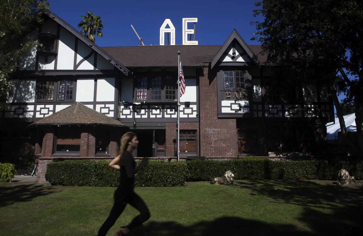A USC student runs in front of the Sigma Alpha Epsilon house in October 2013 on the university's "fraternity row." The fraternity has been put on probation after a student from another college fell from a table during a party and was taken to the hospital.