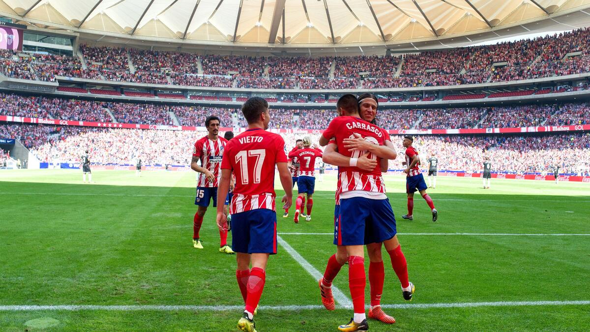 Yannick Carrasco celebrates with Felipe Luis after scoring his team's opening goal during Saturday's match between Atletico Madrid and Sevilla at the new Wanda Metropolitano Satdium.