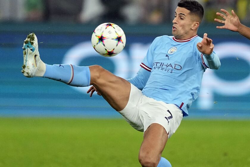 FILE -- Manchester City's Joao Cancelo, left, plays the ball during the Champions League Group G soccer match between Borussia Dortmund and Manchester City in Dortmund, Germany, Tuesday, Oct. 25, 2022. Bayern Munich has made an unexpected move to bolster its struggling team by signing Portugal left back Joao Cancelo on loan from Manchester City for the rest of the season. (AP Photo/Martin Meissner, file)