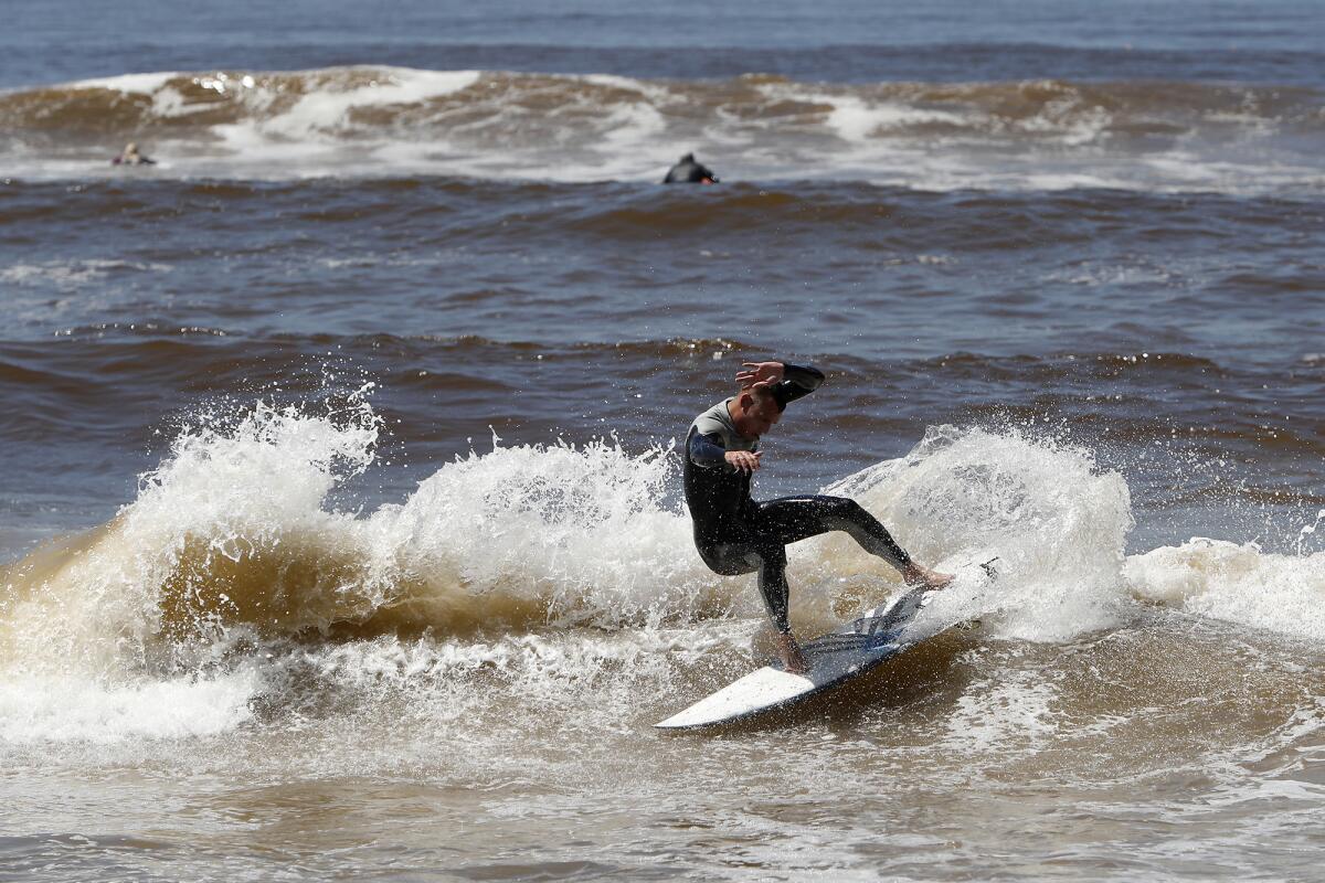 A surfer cuts back on a wave on the south side of Huntington Beach Pier on Friday.