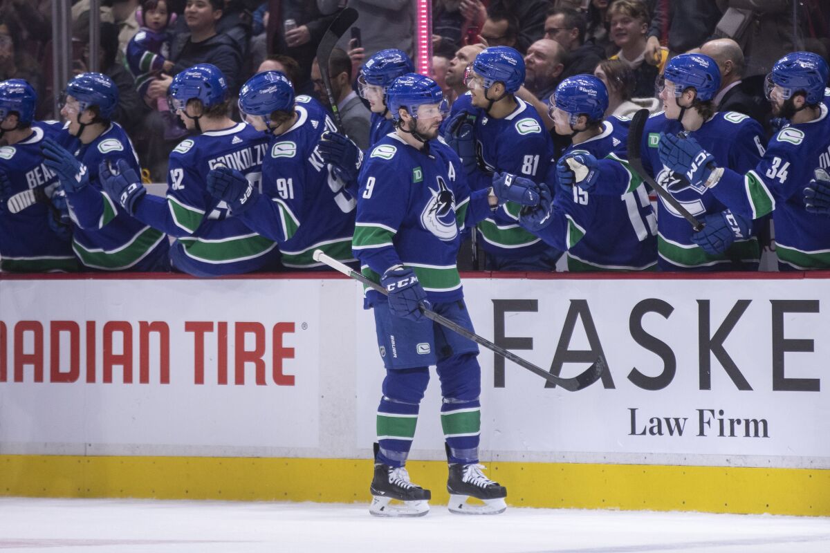 Vancouver Canucks' J.T. Miller (9) celebrates his goal with teammates against the Anaheim Ducks during the first period of an NHL hockey game in Vancouver, British Columbia, Wednesday, March 8, 2023. (Ben Nelms/The Canadian Press via AP)