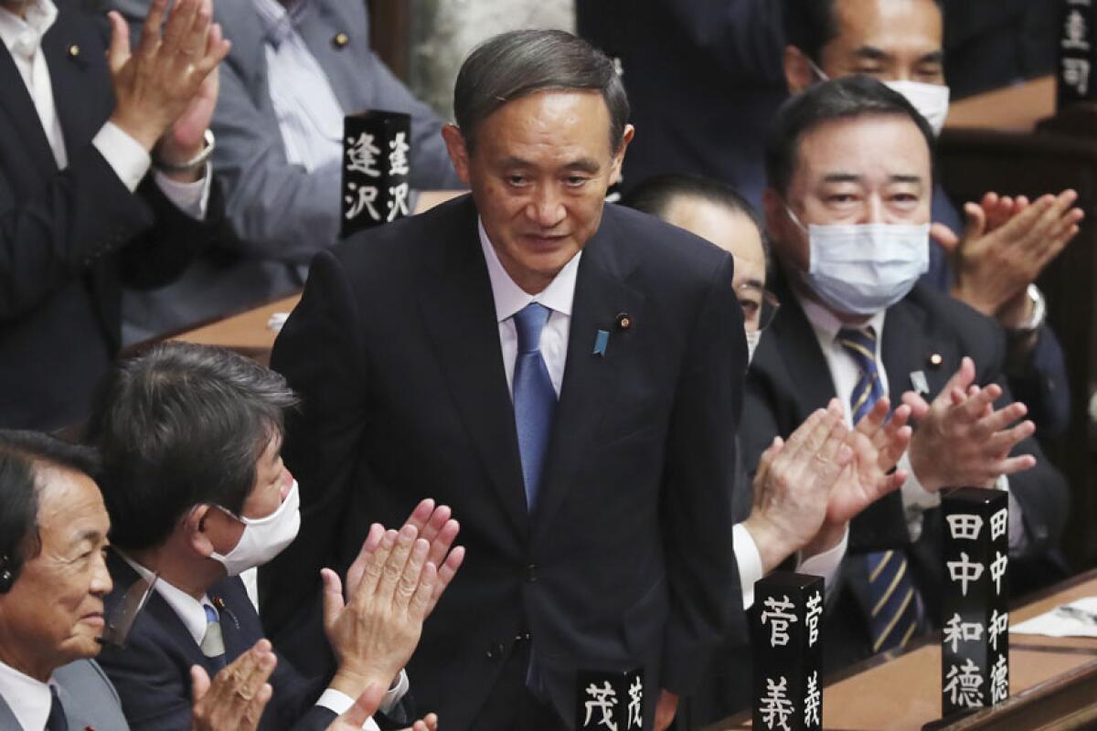 Yoshihide Suga is applauded after being elected Japan's new prime minister.