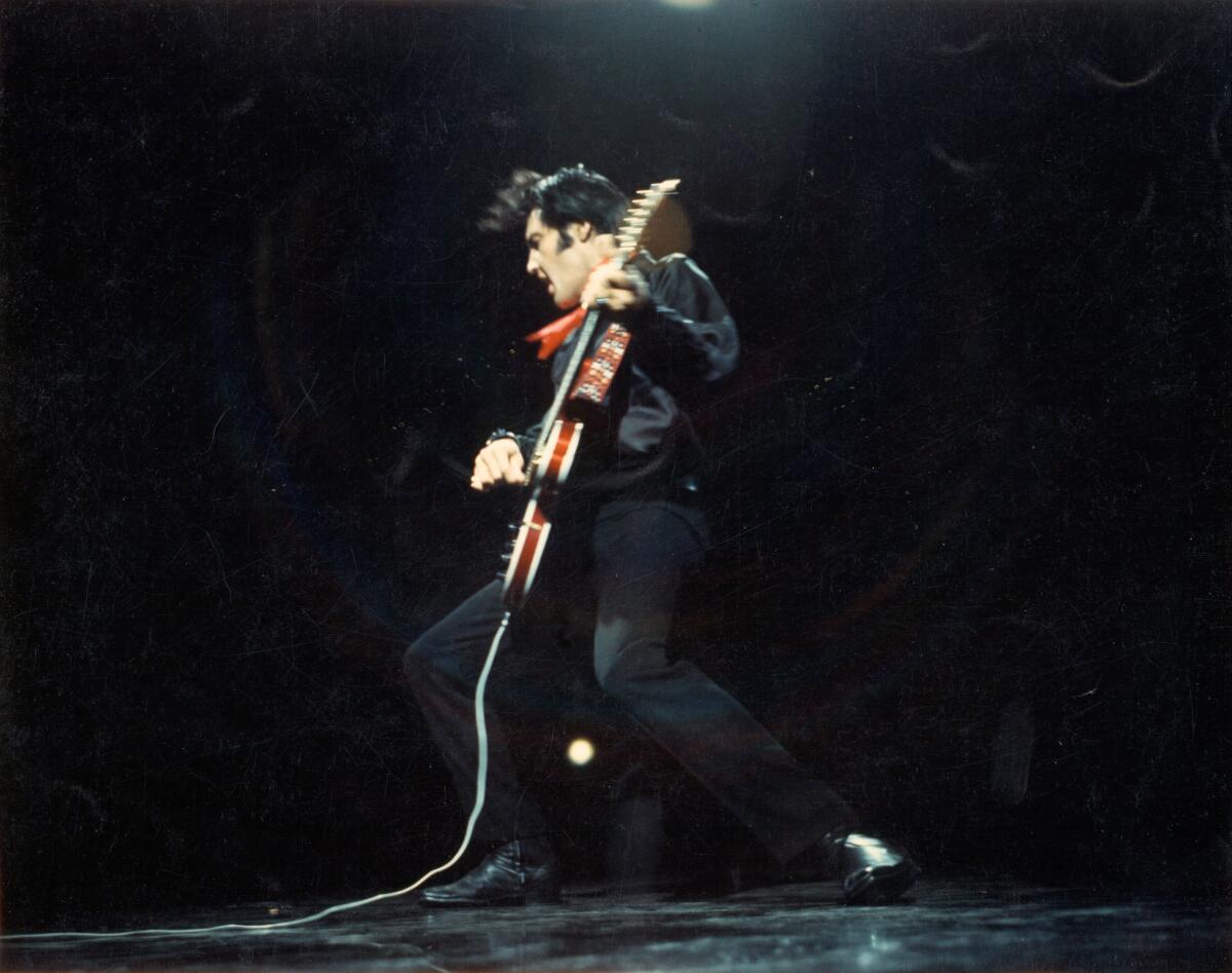 A man playing electric guitar onstage.