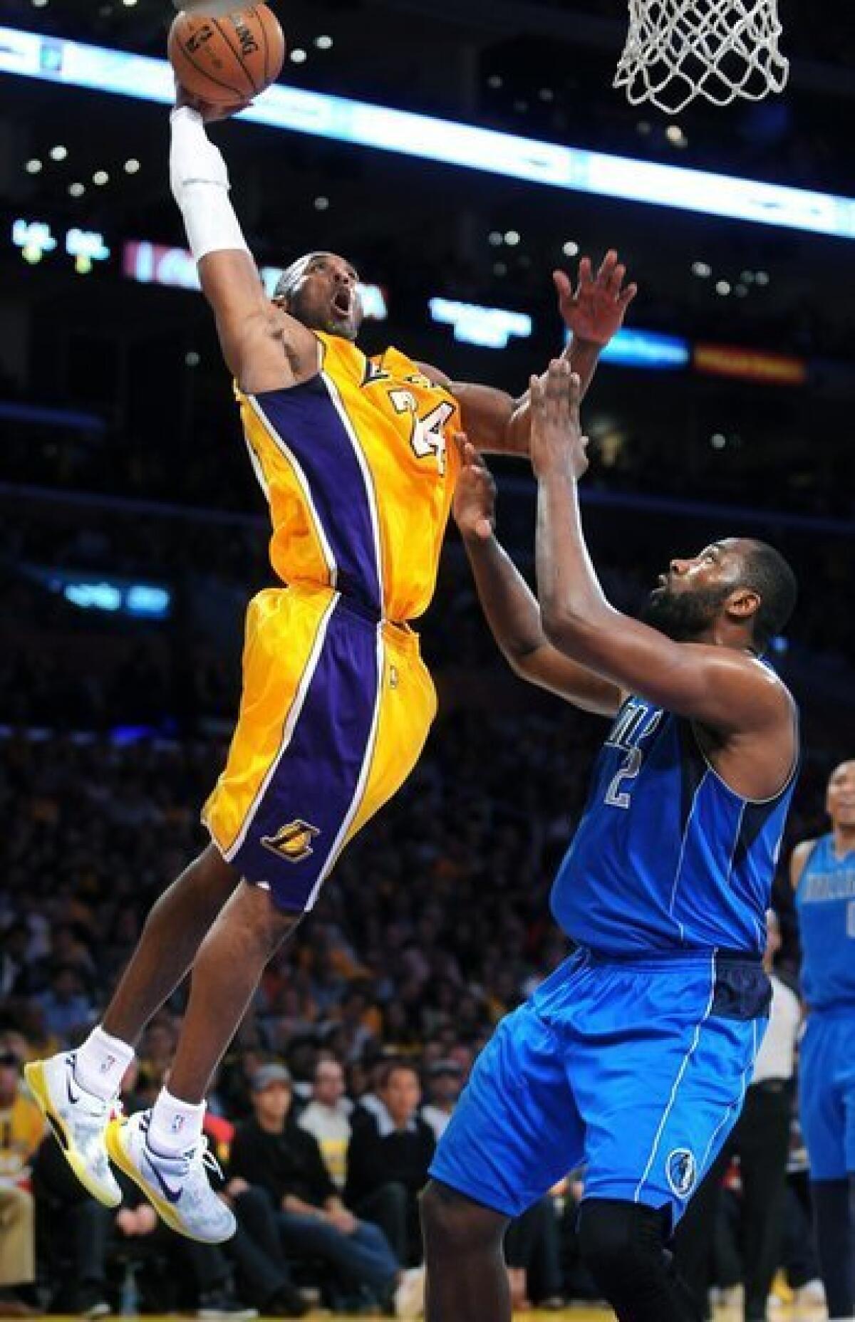 Lakers guard Kobe Bryant goes baseline for a dunk over Dallas Mavericks forward Elton Brand.