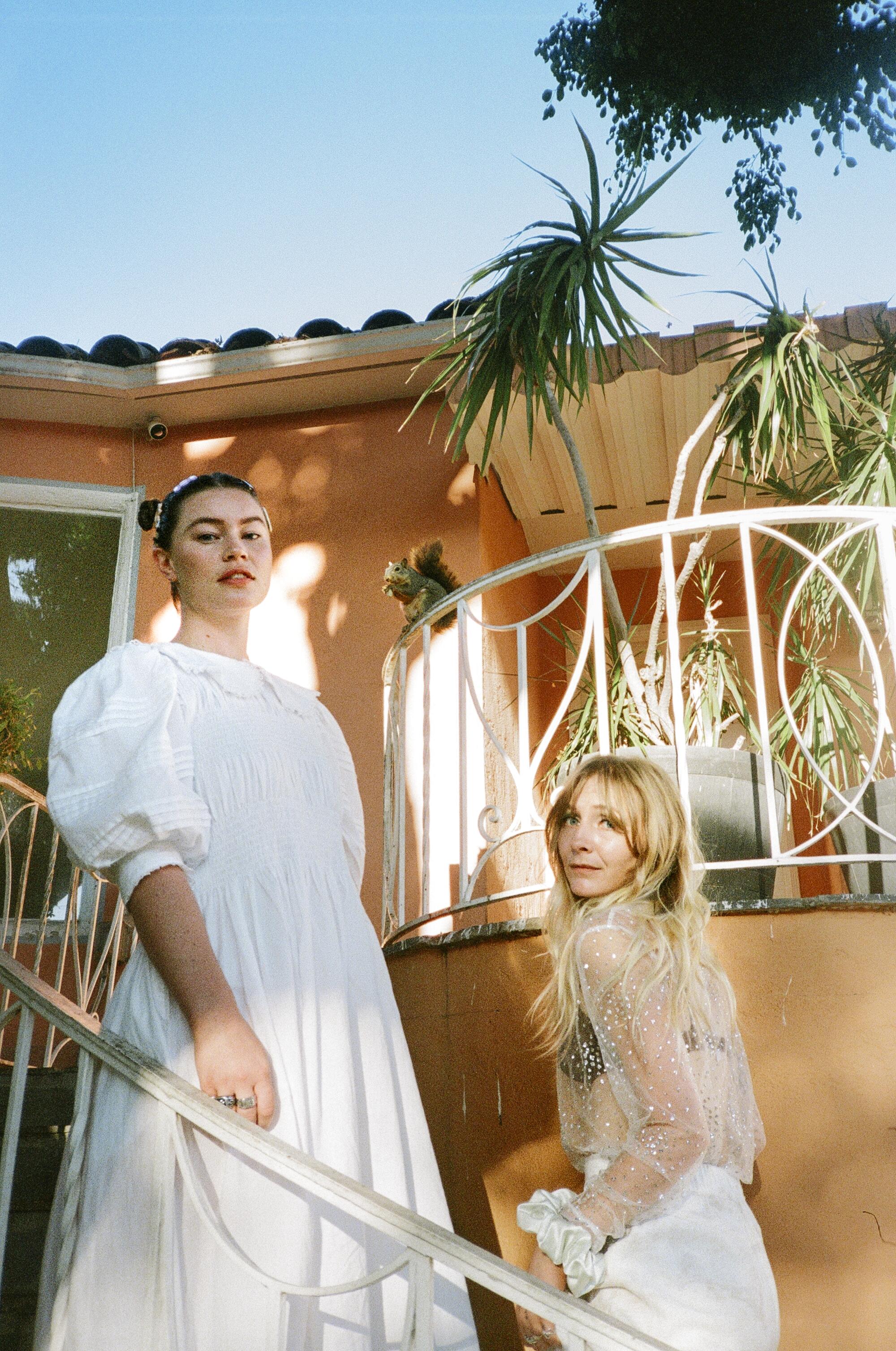 Two women poses on a staircase