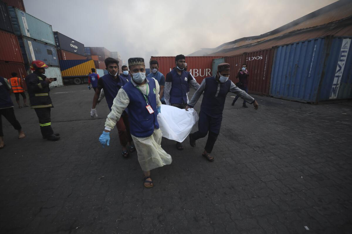 People carry the body of a victim after a fire broke out at the BM Inland Container Depot, a Dutch-Bangladesh joint venture, in Chittagong, 216 kilometers (134 miles) southeast of capital, Dhaka, Bangladesh, early Sunday, June 5, 2022. Several people were killed and more than 100 others were injured in the fire the cause of which could not be immediately determined. (AP Photo)
