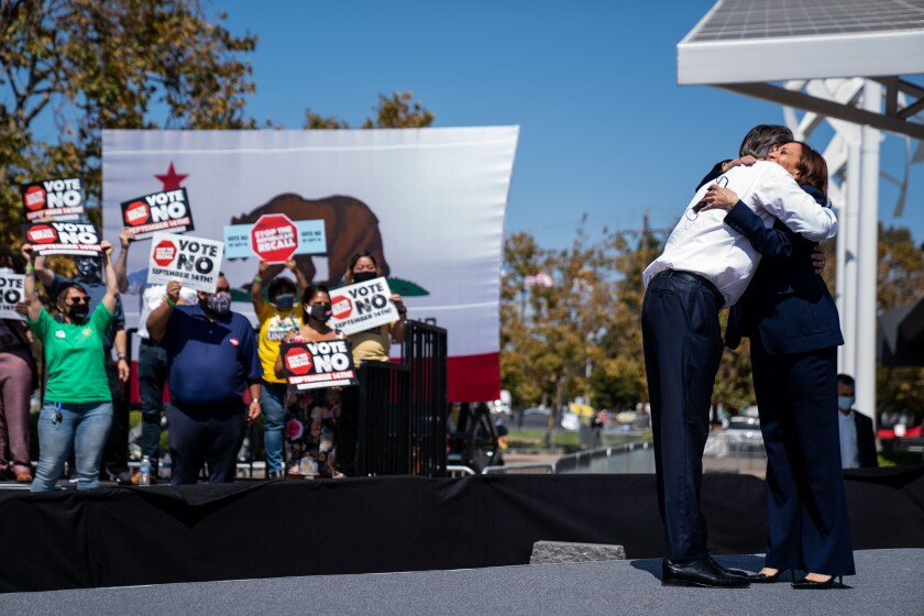 Gov. Gavin Newsom and Vice President Kamala Harris embrace at an anti-recall rally 