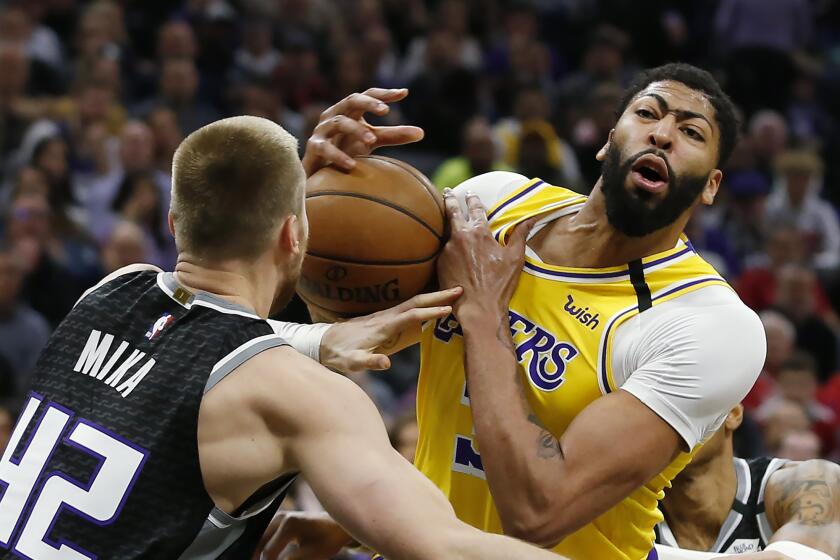 Sacramento Kings center Eric Mika, left, fouls Los Angeles Lakers forward Anthony Davis, right, during the first quarter of an NBA basketball game in Sacramento, Calif., Saturday, Feb. 1, 2020. (AP Photo/Rich Pedroncelli)