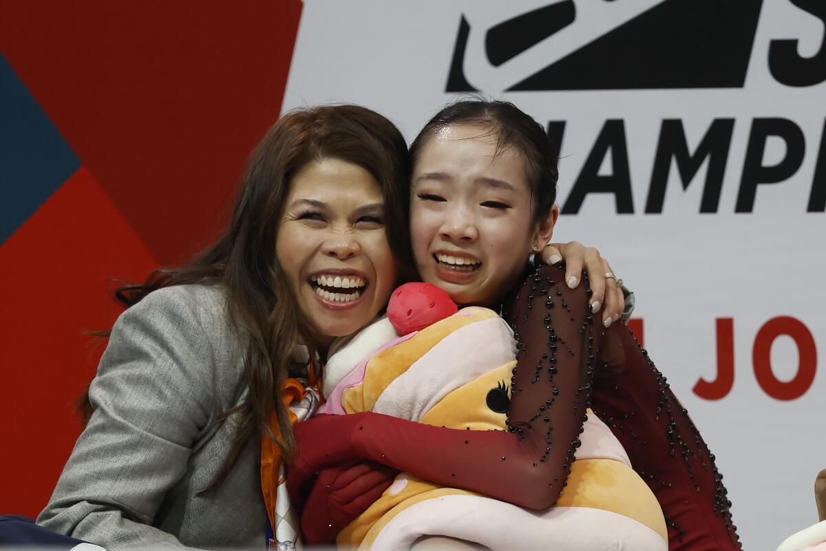 Josephine Lee, right, hugs her coach, Amy Evidente, after learning her free skate score.