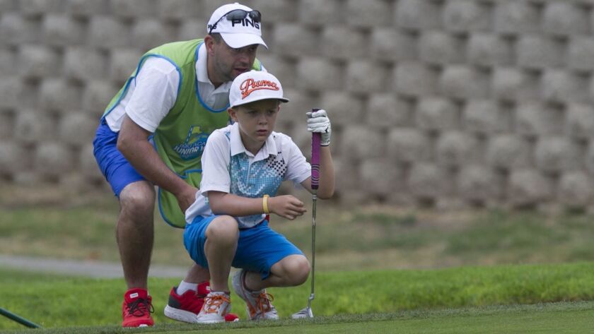 Junior golfer Ellis Kerr, and his father Garry Kerr, who was caddying for Ellis at the Junior World tournament at Sycuan Golf Resort, helped save the life of a man on a course in the UK last summer.
