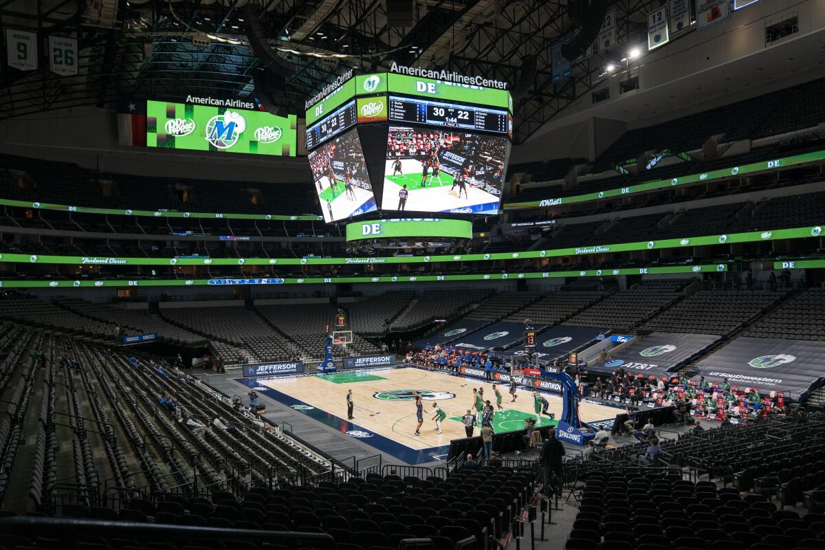 The Orlando Magic and the Dallas Mavericks play in an otherwise empty American Airlines Center in Dallas.