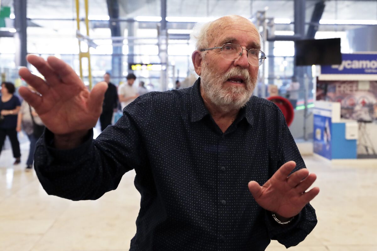 Swiss scientist Michel Mayor gestures after landing at Madrid's Barajas airport on Oct. 8, 2019. He learned of his Nobel win before he boarded the plane.