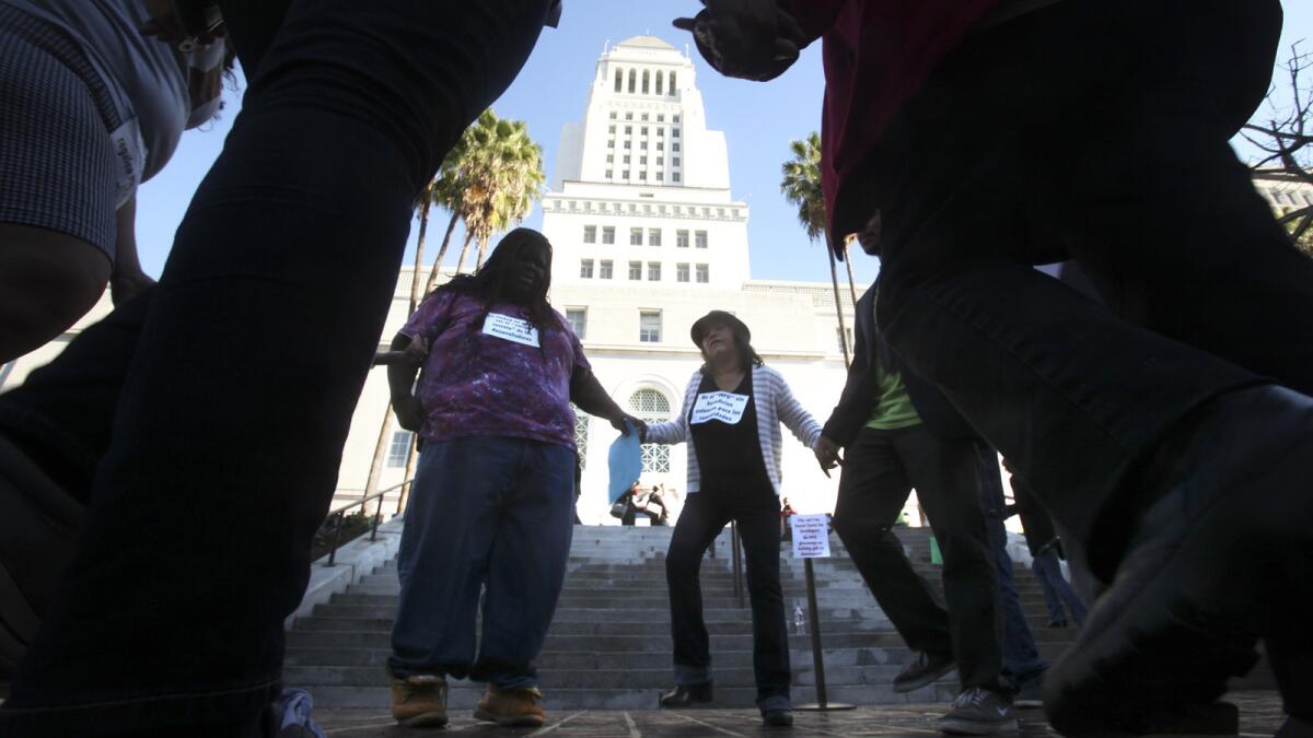 A group of community activists protest on the steps of Los Angeles City Hall in December. Protesters say a new zoning plan does too little to protect affordable housing.