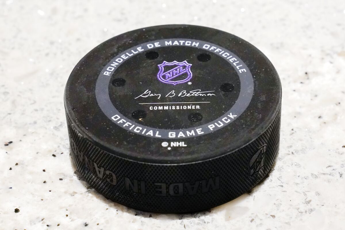 An NHL hockey puck with sensors is shown, Tuesday, Oct. 5, 2021, in Detroit. The NHL is using real-time tracking technology in pucks and on the back of players' jerseys, shooting to generate more data for teams, broadcasters, fans and gamblers. (AP Photo/Paul Sancya)