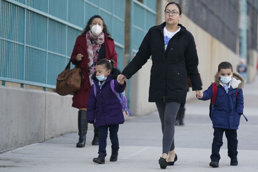 FILE - Children and their caregivers arrive for school in New York, Monday, March 7, 2022. The Biden administration will extend for two weeks the nationwide mask requirement for public transit as it monitors an uptick in COVID-19 cases. The Centers for Disease Control and Prevention was set to extend the order, which was to expire on April 18, by two weeks to monitor for any observable increase in severe virus outcomes as cases rise in parts of the country. (AP Photo/Seth Wenig, File)