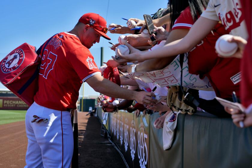 Los Angeles Angels' Mike Trout signs autographs prior to a spring training baseball game against the Arizona Diamondbacks, Saturday, March 2, 2024, in Tempe, Ariz. (AP Photo/Matt York)