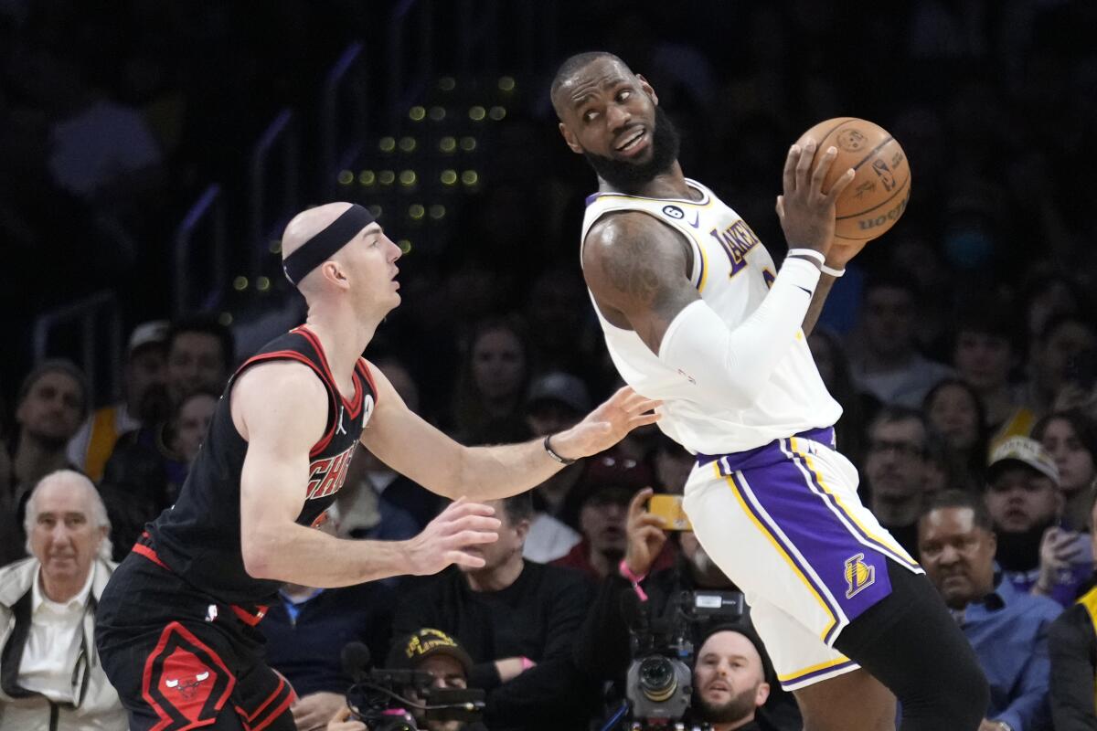 Lakers forward LeBron James leans backward into the forearm of Bulls guard Alex Caruso while working the post.