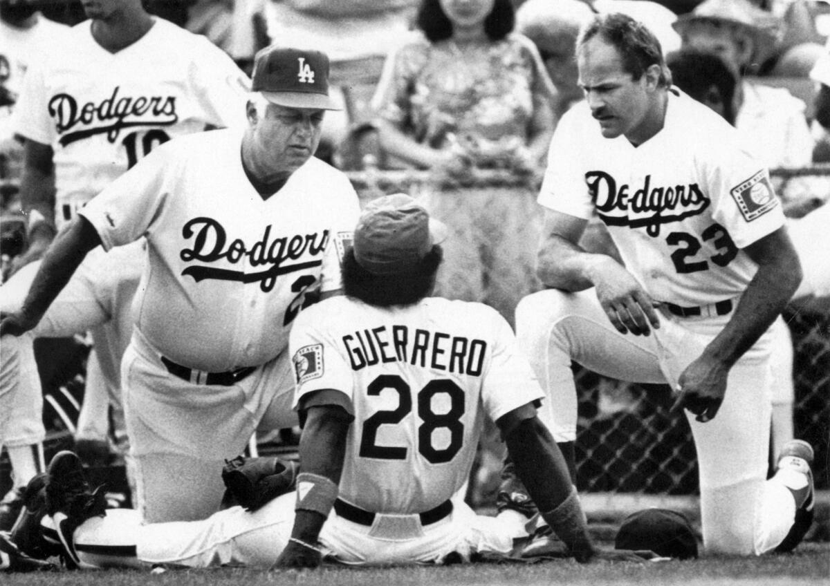 Tommy Lasorda, left, speaks with outfielders Pedro Guerrero, center, and Kirk Gibson before an exhibition game against the Minnesota Twins in Vero Beach, Fla., on March 4, 1988.