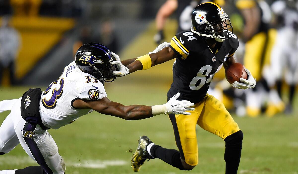 Steelers wide receiver Antonio Brown breaks a tackle by Ravens defensive back Will Hill during a 54-yard touchdown pass play in the fourth quarter Sunday night in Pittsburgh.