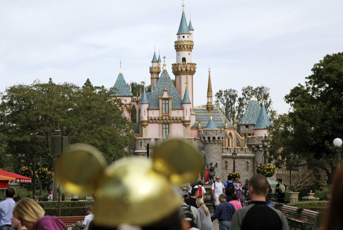 Visitors walk toward Sleeping Beauty's Castle at Disneyland.