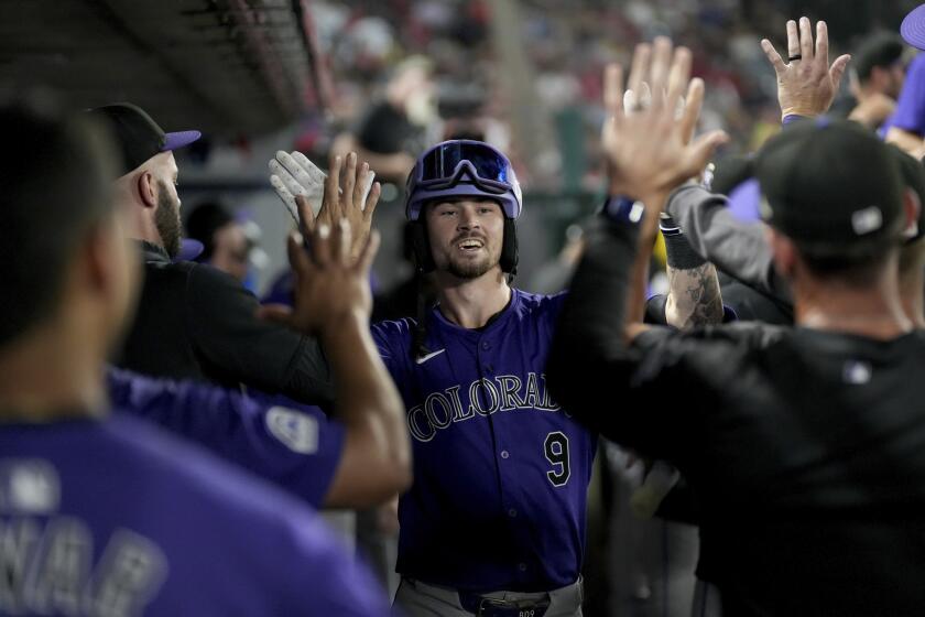 Brenton Doyle de los Rockies de Colorado celebra con sus compañeros su jonrón en la octava entrada ante los Angelinos de los Ángeles el miércoles 31 de julio del 2024. (AP Foto/Eric Thayer)