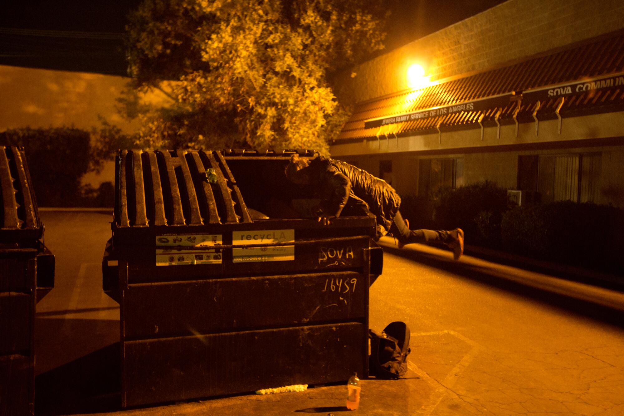 Elizabeth Bolton looks for food in a dumpster in Van Nuys in April 2019.