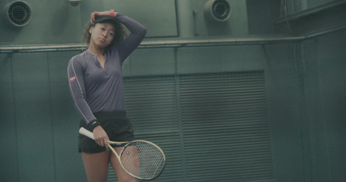 Naomi Osaka holding a tennis racket.