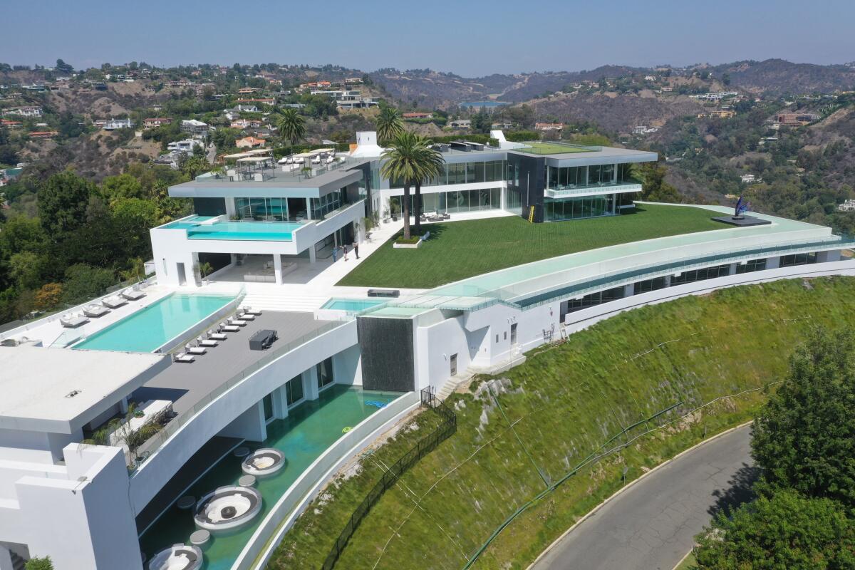 An opulent white house built into a green hillside