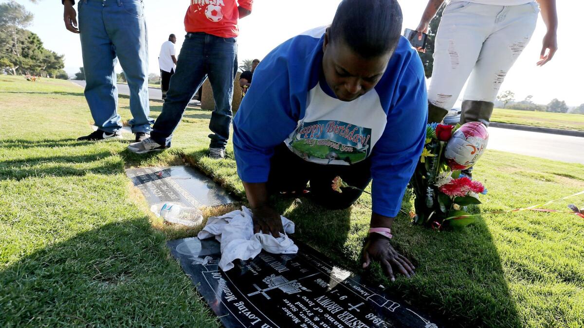 Barbara Pritchett-Hughes cleans the headstone of her son Dovon during a visit to his grave in Inglewood Park Cemetery on what would have been his 25th birthday. Pritchett-Hughes has lost two children to gun violence.