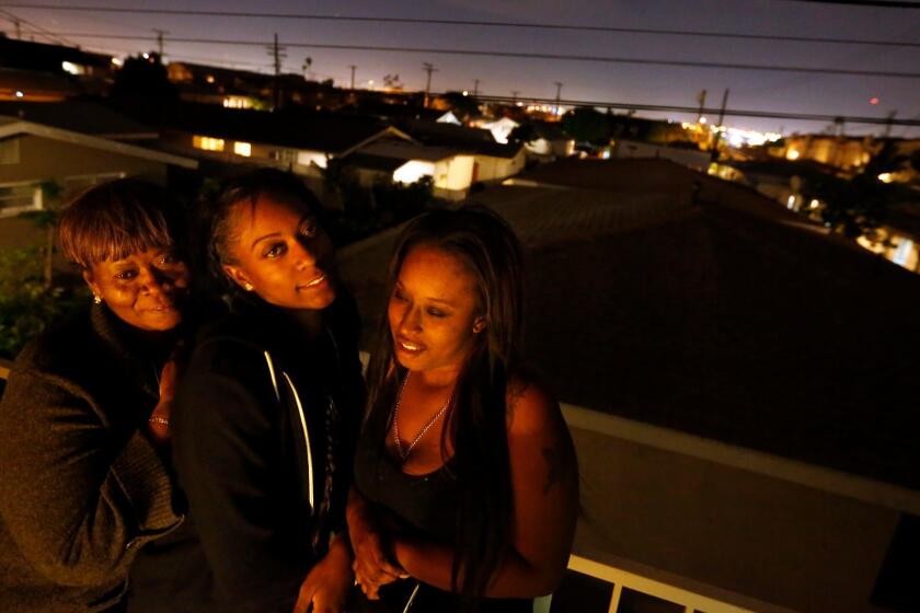 From left, Elvira Evers and her daughters, Jessica Evers-Jones and Lionela Evers, on the balcony of Lionela's apartment in Gardena.