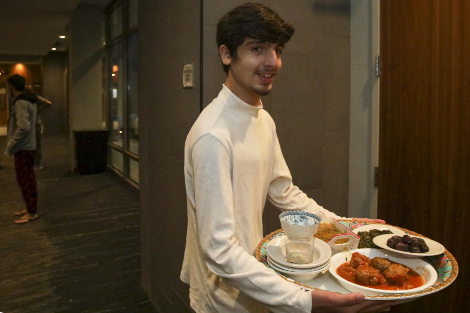 A person holds a tray of food.