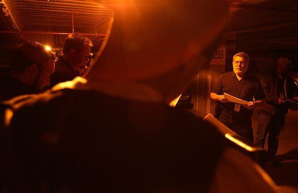 Rafael Lugo, a U.S. Immigration and Customs Enforcement officer, right, briefs team members in an underground garage in downtown Los Angeles before heading out to arrest slaying suspect Oliverio Grijalva Carrillo, who allegedly fled to the United States from Guatemala to avoid prosecution.